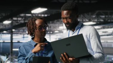 Veri merkezi sistem yöneticileri AI LLM görselleştirmelerini gözden geçirmek için dizüstü bilgisayar kullanıyorlar. Afrika kökenli Amerikan bilişim uzmanları sinirsel ağların çıktılarını analiz etmek için aygıt kullanırlar.