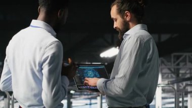 Veri Merkezi ekip lideri ve AI ekipman platformlarının performans göstergelerini inceleyen işçi. Sunucu odası denetleyicisi, programcıyı denetler. Ekranda inceleme makinesi öğrenme algoritmaları, kamera B