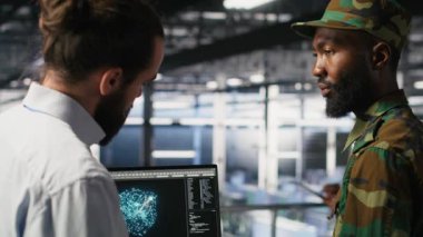 Ağ performansını gözden geçirmek için bilgisayardaki AI LLM teknolojisini kullanan askeri sunucu odası bilgi işlem uzmanları. Ordu operatörleri görevi destekleyen donanım sistemlerini yönetiyor. Kritik bağlantı, kamera B