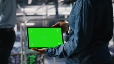 Sunucu merkezi mühendisleri krom anahtar aygıtı kullanarak yapılandırmaları inceliyor. Veri Merkezi Endüstriyel Platformu 'ndaki teknisyenlerin kapatılması, izole ekran tabletindeki performans çıktılarını analiz etmek, kamera B