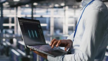 Veri merkezindeki mühendis ve meslektaşım dizüstü bilgisayardaki büyük dil modeli görselleştirmelerini inceliyor. Bilişim mühendisliği ekibi, istikrarlı altyapı işlemleri için sinirsel ağ performans çıktılarını analiz ediyor