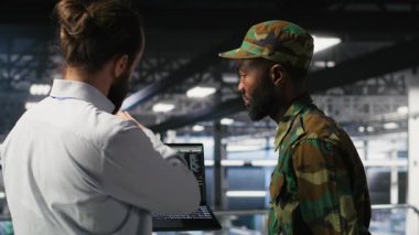 Yüksek teknoloji sunucu tesisinde yapay zeka hesaplama operasyonlarını askeri birimler denetliyor. Ordu teknoloji uzmanları iletişim sistemlerini denetlemek için makine öğrenme zekası kullanıyorlar.