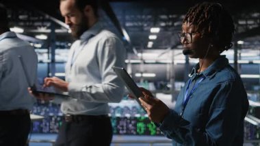 Veri merkezi mühendisi kulaklık takarak tablet kullanarak uzaktan tanı koyuyor. Teknisyen sistem sağlığını izliyor ve kullanıcılara altyapı sorun çözme adımları ve kamera A yoluyla rehberlik ediyor