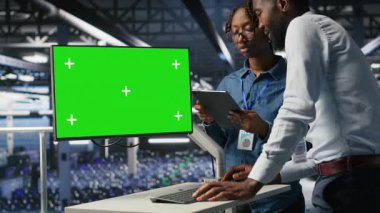 Sunucu merkezi meslektaşları beyin fırtınası yapıyor. Teşhisleri gözden geçirmek için kroma anahtar cihazını kullanıyorlar. Veri merkezinde bakım görevleri yapan çalışanlar, yeşil ekran görüntüsüne bakıyorlar