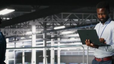 Veri merkezindeki sistem yöneticileri sinirsel ağ LLM görüntülemesini izlemek için dizüstü bilgisayar kullanıyorlar. Sunucu merkezi ekip çalışanı platformları denetliyor makine öğrenme süreçlerine güç veriyor, kamera B