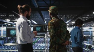 Ağ performansını gözden geçirmek için bilgisayardaki AI LLM teknolojisini kullanan askeri sunucu odası bilgi işlem uzmanları. Ordu operatörleri görevi destekleyen donanım sistemlerini yönetiyor. Kritik bağlantı, kamera A