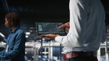 Veri merkezinde tablet görüntüleme programcısını kapat, bakım görevleri yap, en iyi performansı sağla. IT uzmanı aygıt üzerindeki kodu kontrol ediyor, istikrarı artırmak için yamalar uyguluyor, kamera A