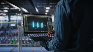 Veri merkezindeki yönetimi nöral ağ LLM görüntülemesini izlemek için dizüstü bilgisayar kullanarak kapat. Sunucu merkezi bilişim uzmanı, platformlara güç veren makineleri denetliyor. Not defteri, kamera A kullanarak öğrenme işlemlerini yapıyor.