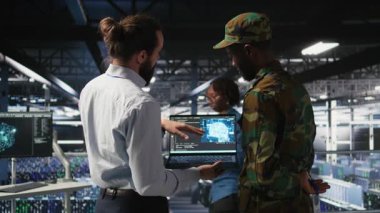 Güvenli veri merkezindeki askeri teknisyenler yapay zeka sistemlerini izlemek için dizüstü bilgisayar kullanıyorlar. Ordu operatörleri sunucu merkezinde makine öğrenme işlemleri için istikrarlı altyapı sağlıyorlar, kamera A