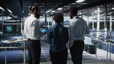 Veri merkezindeki yazılım geliştiricileri AI LLM görselleştirmesini izliyor. Sunucu çiftliği takım arkadaşları beyin fırtınası yapıyor, sondaj kulelerini denetliyor makine öğrenme süreçleri, kamera A