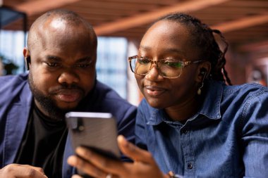 Siyahi çift, video konferansında iş arkadaşlarını karşılıyor. Evlerinden online iletişim yoluyla uzak bir işin faydalarından faydalanıyorlar. Sanal brifing toplantısı.