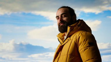 Erkek kaşif yüksek rakımlı vahşi doğanın yalnızlığını kucaklıyor, temiz hava ve manzaralı bir arka plan için dağın tepesine tırmanıyor. Doğadaki farkındalık ve rahatlama. Kamera B.