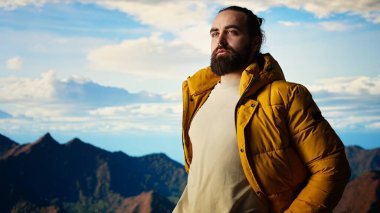 Azimli tırmanışçılar gökyüzüne ve kayalık dağ tepelerine bakıyorlar. Sınırların ötesine geçmek için gereken direnç ve hırsı yansıtıyorlar. Nefes kesici ufuk çizgisi manzarası maceraya ilham verir. Kamera A.