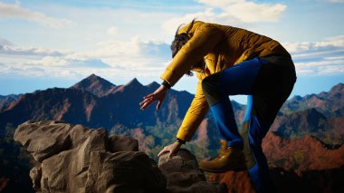 Şiddetli rüzgarla savaşan ve daha iyi bir telefon sinyali arayan genç yürüyüşçü, dağın tepesindeki akıllı telefon tarafından dikkatsiz davranıyordu. Manzaralı bir zirvenin sarp kayalıklarında yuvarlanarak. Kamera A.