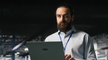 Veri merkezi platformunda nöral ağ LLM görüntülemesini izlemek için dizüstü bilgisayar kullanan programcı. Endüstriyel sunucu çiftliği bilişim profesyoneli donanımlara güç veren makine öğrenme işlemlerini denetliyor