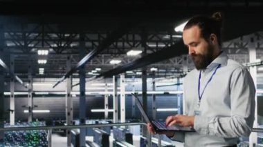 Bilgisayarı elinde tutan teknisyen çiftlik platformunda yürüyor, yapay zeka makinesini otomatik öğreniyor. Not defteri kullanarak veri merkezi programcısı, yapay zeka kullanarak bakım yapıyor, kamera B