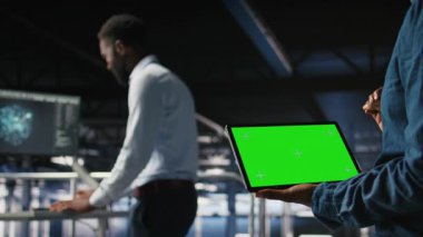 Sunucu merkezi mühendisleri krom anahtar aygıtı kullanarak yapılandırmaları inceliyor. Veri Merkezi Endüstriyel Platformu 'ndaki teknisyenlerin kapatılması izole ekran tabletindeki performans çıktılarını analiz ediyor, kamera A