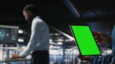 AI LLM görselleştirmesini gözden geçiren meslektaşın yanında izole ekran tableti kullanarak sunucu merkezini kapat. Veri merkezi çalışanı, makine öğrenme sistemlerini, kamera A 'yı izlemek için model aygıtı kullanıyor.