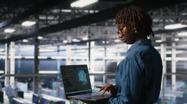 Veri merkezindeki sistem yöneticileri AI LLM görüntülemesini izliyor. Afrika-Amerika sunucu çiftliği iş arkadaşları teçhizata güç veren makine öğrenme süreçlerini denetliyor, kamera B