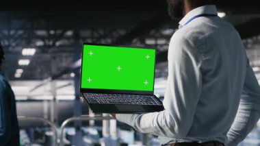 Endüstriyel platformdaki veri merkezi programcıları yeşil ekran dizüstü bilgisayar kullanarak görevlerde işbirliği yapıyorlar. Sunucu merkezi çalışanları büyük dil model mimarisini maket defteri ve bilgisayar kullanarak görselleştiriyor