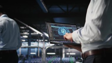 Sunucu odasında yapay zeka öğrenme otomatikleştirmesi yapan bilişim uzmanını kapat. Veri merkezi yazılım geliştiricisi, defter kullanarak donanım bakımı yapıyor. Yapay zeka, kamera A kullanarak.