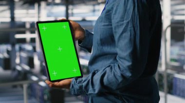 Veri merkezi çalışanı yeşil ekran taklit tableti kullanıyor, yapay zeka görevleriyle ilgilenen tırların bakımını yapıyor. Derin öğrenmeyi destekleyen depolama dizilerini yönetmek için krom anahtar aygıtı kullanan sunucu merkezi yönetimi, kamera B