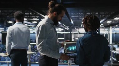 Nöro ağ kodunu ve LLM görselleştirme panellerini inceleyen mühendis tarafından yapılan işi denetleyen sunucu çiftlik yöneticisi. Ekip lideri AI sistem performansını izleyen işçi denetleme, kamera A