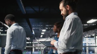 Veri merkezi endüstriyel platformdaki programcılar tablet üzerindeki kodları kontrol ediyorlar, yazılım güncellemeleri yapıyorlar. Sunucu çiftliği bilişim uzmanları işbirliği yapıyor, düzenleme paraşütleri ayarları, kamera A