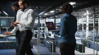 Veri merkezi yazılım geliştiricisi dizüstü bilgisayarda kritik hata görüntüsü aldıktan sonra panikledi. Sunucu merkezindeki Afrikalı Amerikalı kadın, düşük donanım performansına neden olan cihazlar yüzünden alarma geçti. Kamera A