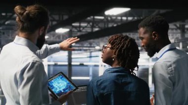 Veri merkezindeki yazılım geliştiricileri AI LLM görselleştirmesini izliyor. Sunucu çiftliği takım arkadaşları beyin fırtınası yapıyor, sondaj kulelerini denetliyor makine öğrenme süreçlerini, kamera B