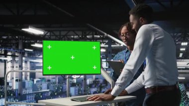 Sunucu odası çalışanları beyin fırtınası yapıyor. Teşhisleri gözden geçirmek için kroma anahtarı kullanıyorlar. Veri merkezinde bakım işleri yapan çalışanlar, izole ekran monitörüne, kamera A 'ya bakıyorlar.