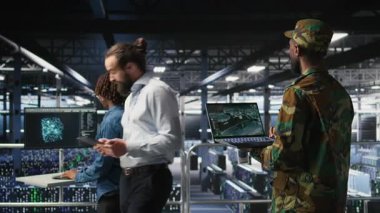 Veri merkezindeki askeri teknisyen bilgisayardaki uzaktan kumandalı savaş uçağı ölçümlerini izliyor. Ordu sunucu odasında bilişim uzmanı. Hava operasyonlarını desteklemek için dizüstü bilgisayarda taktik arayüzü kullanıyor. Kamera A