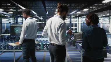 Veri Merkezi Mühendislik Ekibi yapay zeka işleme için kullanılan sunucuların bakımını yapıyor. IT uzmanları, tablet, kamera A ile makine öğrenme eğitiminde kullanılan veri merkezi dizilerini yönetir.