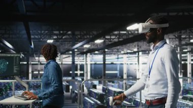 VR kulaklığı kullanarak veri merkezi yönetimi nöral ağ yapay zeka sistemlerini izliyor. Sunucu odası çalışanı sanal gerçeklik teknolojisini kullanarak makine öğrenme süreçlerini denetliyor, kamera A