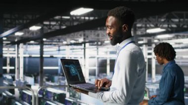 Veri merkezindeki programcı ve meslektaşım bilgisayardaki AI LLM görselleştirmelerini inceliyor. IT ekip çalışanları, istikrarlı altyapı işlemleri sağlamak için nöral ağ performans çıktılarını analiz ederler