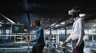 VR kulaklığı kullanarak sunucu teknolojisini güncelleyen bir mühendis, yazılım araçları kullanarak ekipmanları yapılandırıyor. Sanal gerçeklik kullanarak donanım analizlerini inceleyen sunucu merkezi çalışanı, kamera A