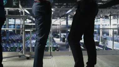 Veri Merkezi ekip lideri ve AI ekipman platformlarının performans göstergelerini inceleyen işçi. Sunucu odası denetleyicisi, programcıyı denetliyor. İnceleme makinesi öğrenme algoritmaları ekranda, kamera A