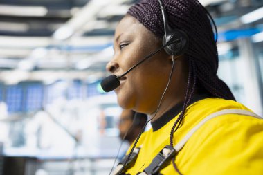 Güneş enerjisi üretim sistemlerinde kulaklık kullanan yardım hattı çalışanı sorunları, fotovoltaik arızalara veya yenilenebilir enerji santralindeki teknik sorunlara destek veren kadın.