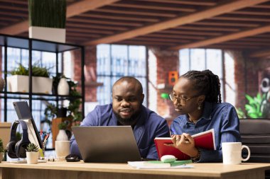 Afrika kökenli Amerikalı çift evlerinde uzaktan çalışıyor, iş stratejileri planlıyor ve proje geliştirmeyi tartışırken aynı zamanda bir dizüstü bilgisayarla ilerlemeyi takip ediyor ve başarıyı garantiliyor..