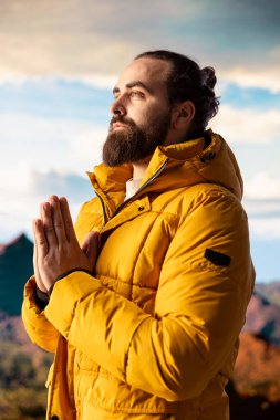 Stres atmak için meditasyon yapan memnuniyet yürüyüşçüsü dağın tepesinde rahatlık ve denge sağlamak için dinleniyor. Genç gezgin, dikkat çekmek için meditasyon yapıyor..