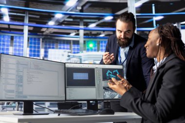 Mutlu fotovoltaik fabrikası programcısı yenilenebilir enerji jeneratörlerinin modellerini oluşturarak müdüre ilerleme gösteriyor. Gülümseyen güneş panelleri bitki geliştirici inşa güneş hücreleri denetleyici ile konuşuyor