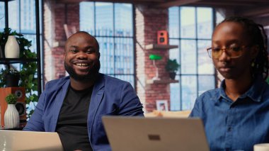 Afrika kökenli Amerikalı çift, iş eğilimlerini araştırmak ve çevrimiçi bir markayı yönetmek için bir dizüstü bilgisayar kullanarak bir yönetim projesi üzerinde birlikte çalışıyorlar. Bir takım olarak başarılı bir uzak kariyer gelişimi. Kamera B.