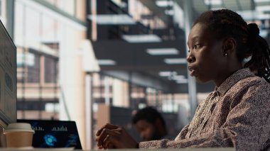 Stratejik planlama için finansal verileri analiz eden Afro-Amerikan personeli etkili iş operasyonları için kaynak tahsisini tartışıyor. Analizci finansal tahminler ve analizler yapar. Kamera A.