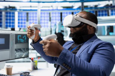 Afrika kökenli Amerikalı usta mühendis güneş enerjisi otomasyonunu geliştirmek için VR kulaklık kullanıyor, çevre dostu. Fotovoltaik üretim fabrikası uzmanı sanal gerçeklik ekipmanı kullanıyor, yüksek teknoloji.