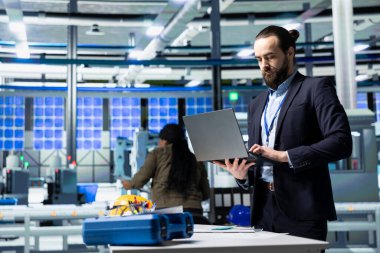 Resmi kıyafet mühendisi fabrika iş akışını değerlendiriyor, iş uzmanlığı ve güneş teknolojisi endüstrisindeki endüstriyel verimliliği birleştiriyor. Temiz enerji ve yenilik.