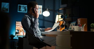 Erkek serbest çalışan, aylık fon dengesi ve küresel yatırımlardan elde edilen karı artırmak için evdeki finans uzmanını arıyor. Genç adam sermaye kaynakları hakkında danışmanla konuşuyor. Kamera A.