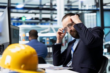 Güneş enerjisi teknisyenleri bir endüstriyel santraldeki panelleri kontrol ederek enerji üretiminin verimli çalışmasını sağlıyorlar. Modern bir iş yerinde çalışan erkek profesyonel danışman..