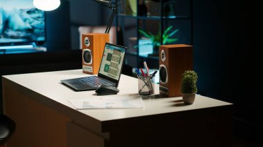 Geniş bir ev ofisi ve ahşap mobilyaları olan şık bir daire, rahat bir TV salonu, dekoratif ev bitkileri ve minimalist bir tasarım modern konforlu bir çalışma alanı ve yaşam alanı oluşturur..