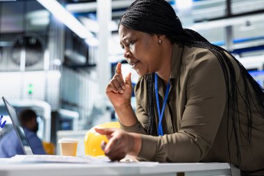 Verimli endüstriyel operasyonlarda sürdürülebilir enerji için şirket liderliğini gösteren, üretiminde kullanılan bir güneş santralindeki üretim hattı sistemini inceleyen kadın genel müdür.