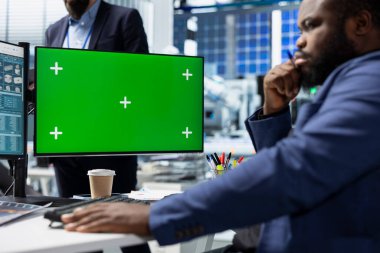 Afrika kökenli Amerikalı enerji uzmanı güneş enerjisi santralindeki fotovoltaik tasarım ve fabrika uygulamaları üzerinde çalışan kopya uzay görüntülerine bakıyor. Uzmanlığı olan şirket denetimi.